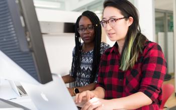 Kaksi opiskelijaa työskentelee tietokoneen äärellä.
