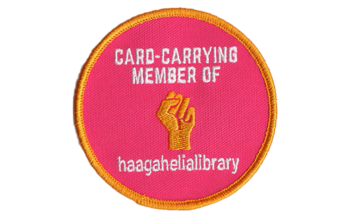 Pinkki haalarimerkki, jossa on teksti &quot;Card-carrying member of haagahelialibrary&quot;.